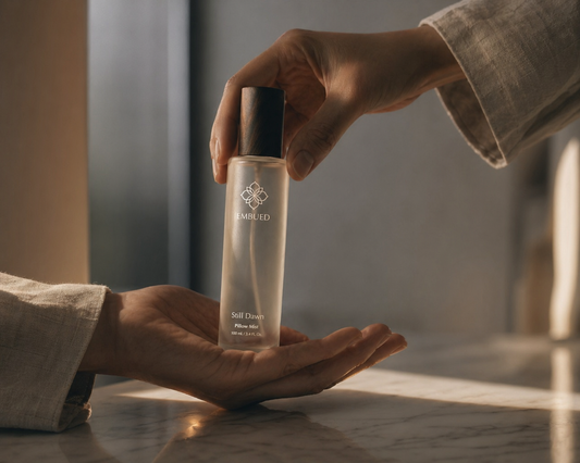 Two hands, one placing a sleep spray bottle into another open palm — thoughtful gifts for people who can't sleep